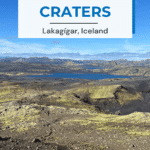 A panoramic view of the Laki craters in Iceland showcases volcanic landscapes with rocky ground and lush green patches in the foreground, set against a backdrop of distant mountains and a blue crater lake.
