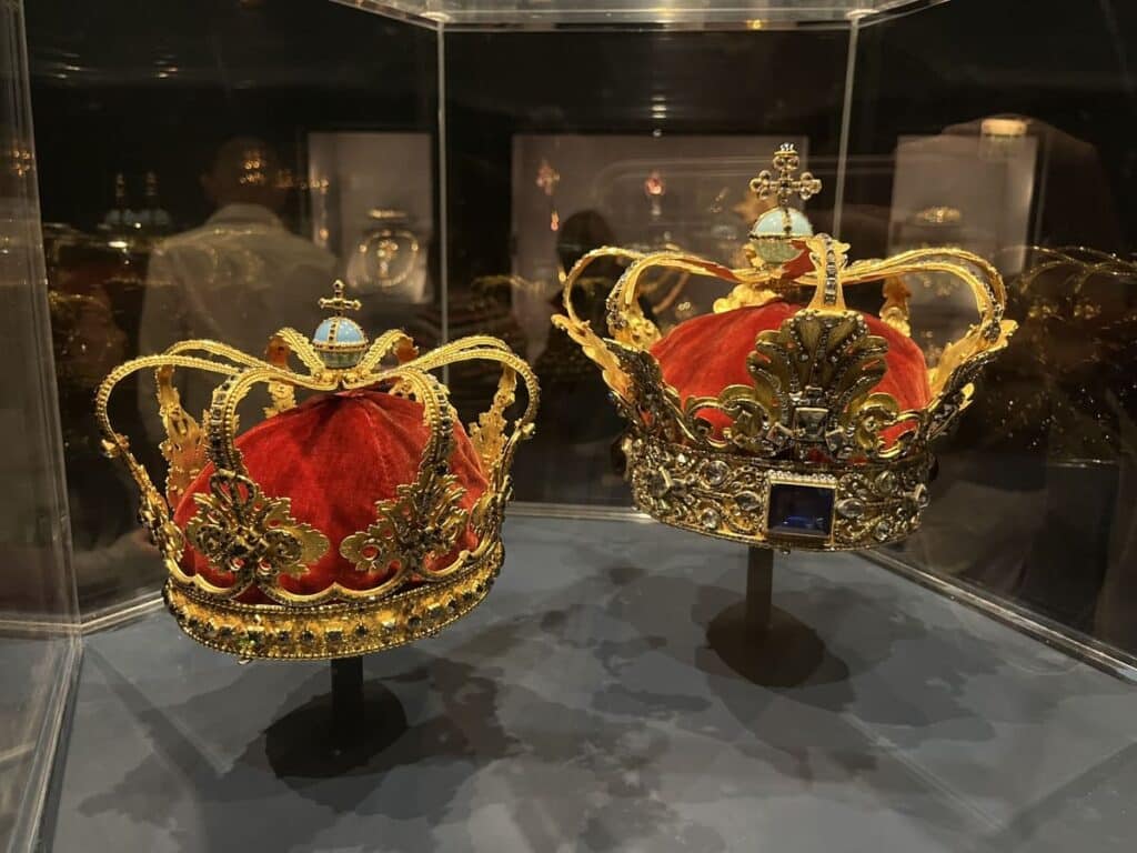 Two royal crowns in a display case in a palace in copenhagen.