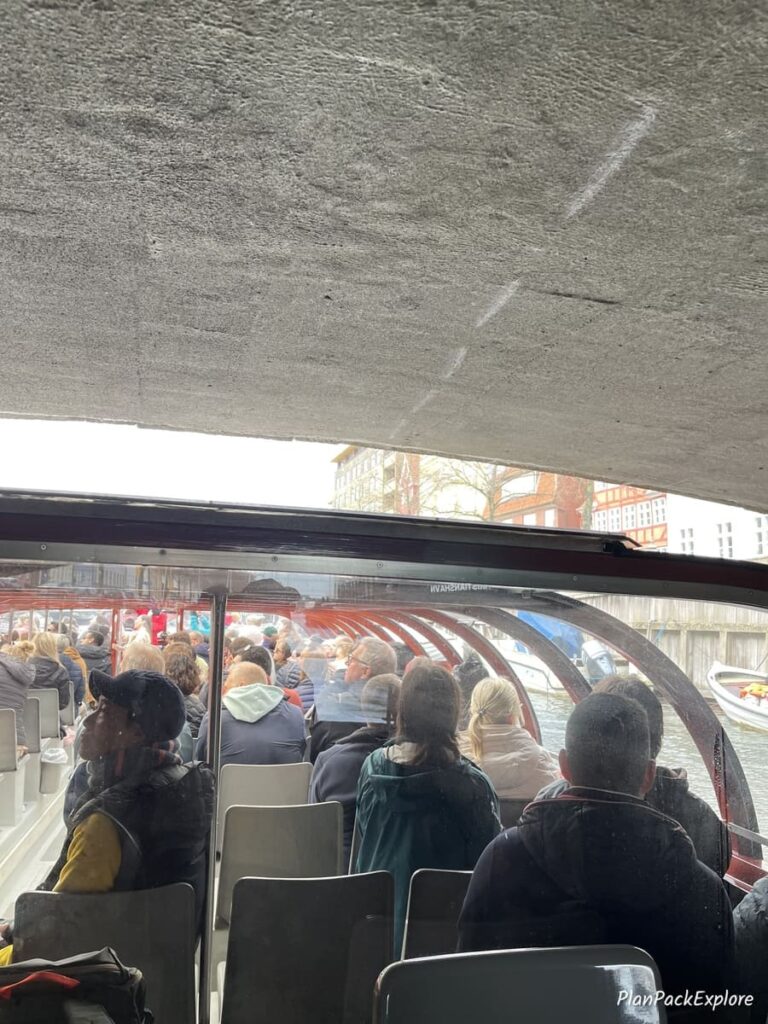 a canal tour boat under a low bridge in Copenhagen Denmark.