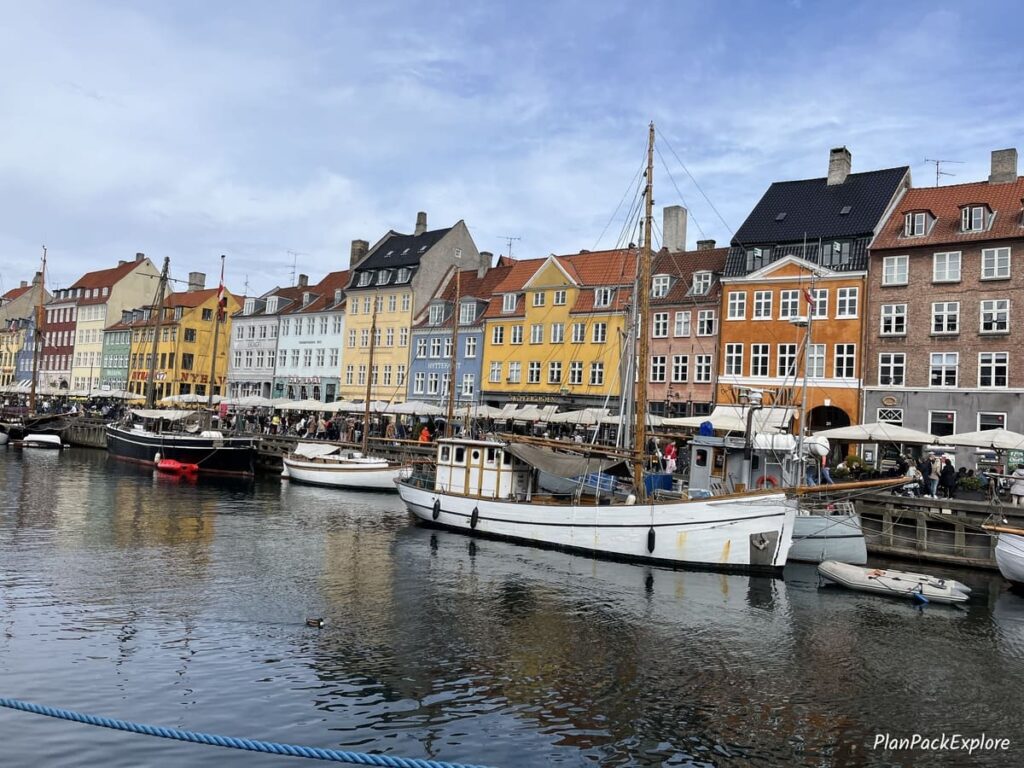 Colorful houses and boats docked along the canal in Nyhavn, Copenhagen, Denmark.