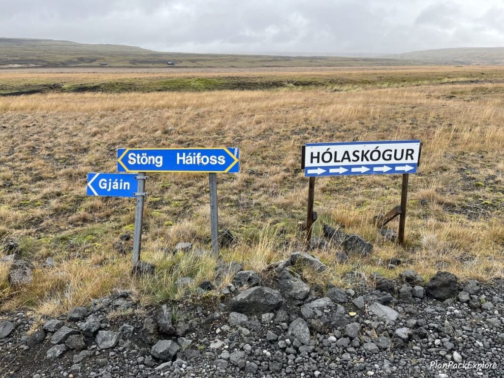A set of blue signs pointing to the direction of Haifoss, Stong and Gjain in Thorsardalur Valley, Iceland.