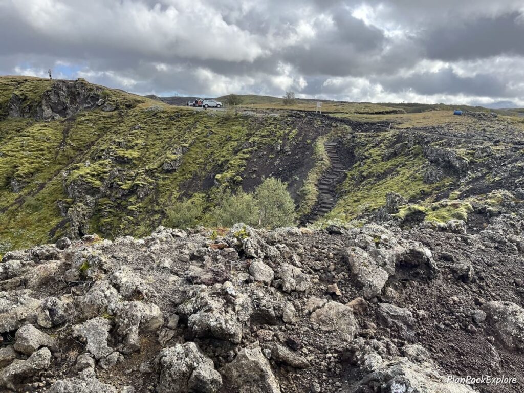 A distant view of the parking lot and narrow stone steps down to Gjain in Thjorsardalur Valley, Iceland.