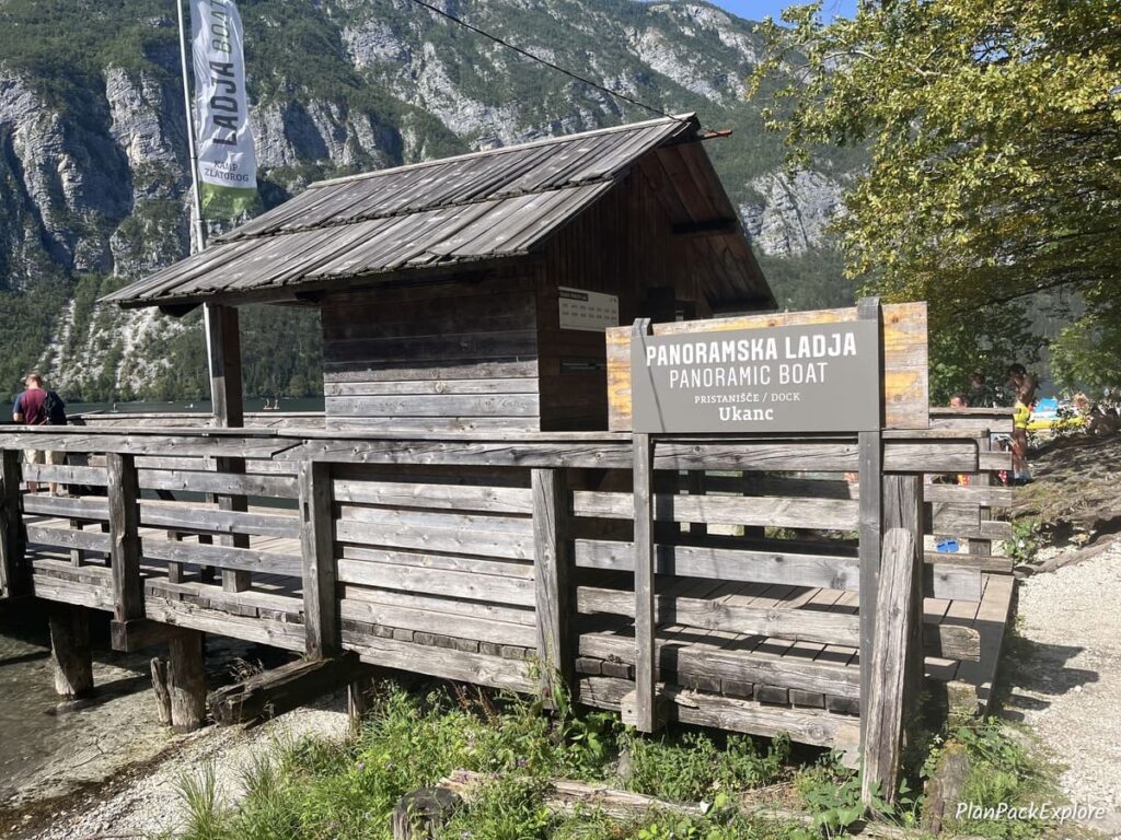 A wooden dock wirh a sign for a panoramic boat at Lake Bohinj campsite in Slovenia.