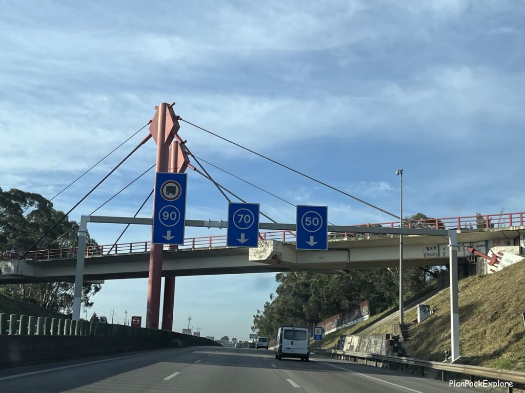 Round blue signs stating minimum speed limits on a motorway in Portugal.