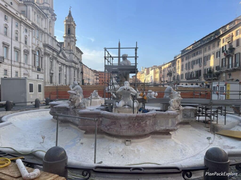 A historic fountain under construction in Piazza Navona in Rome, Italy.