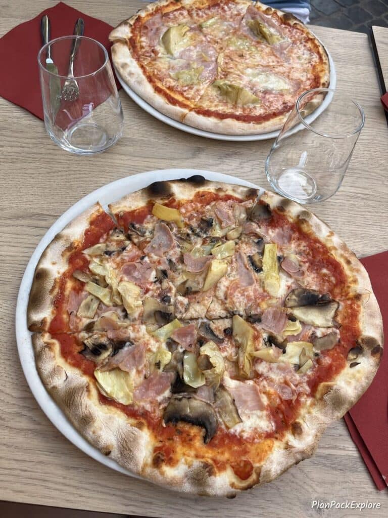 Two plates of pizza on a restaurant table in Rome, Italy.