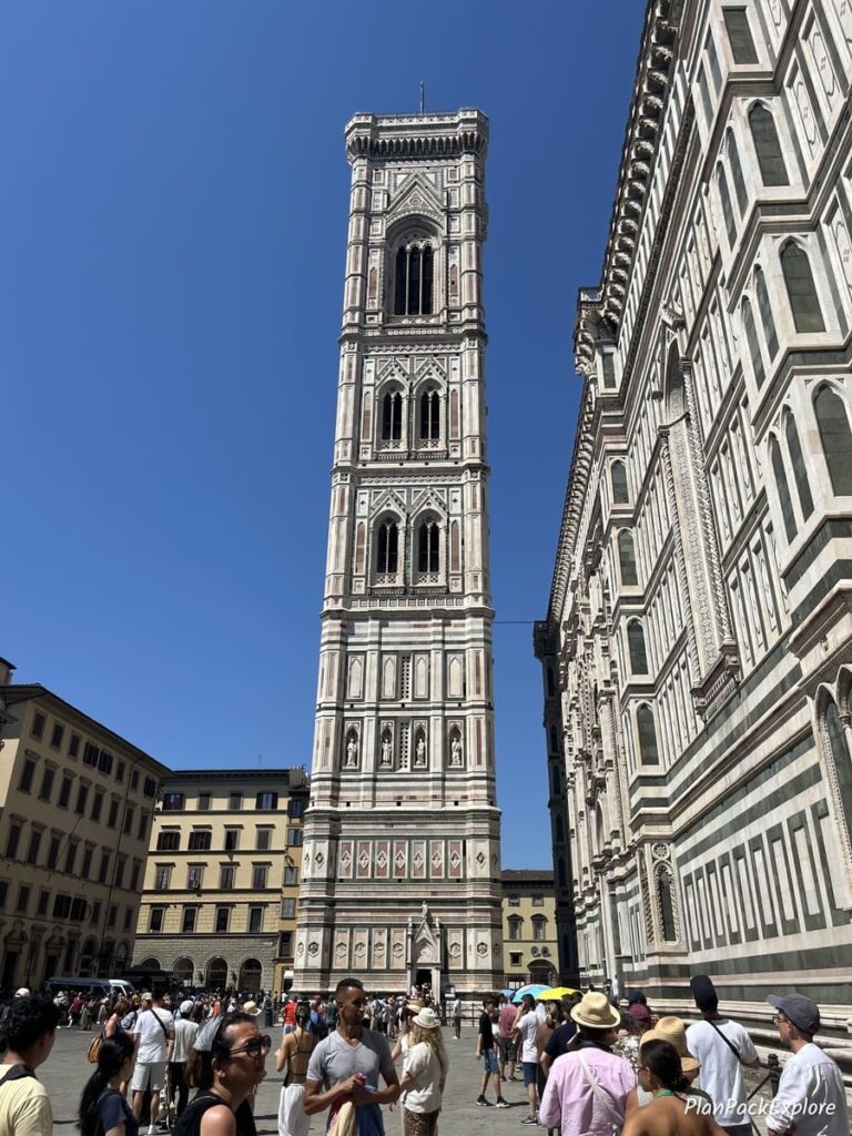 A tall white stone bell tower of the Cathedral in Florence, Italy.