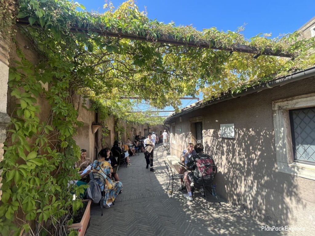 An alley with green vines providing shade at the Castel Sant'Angelo in Rome Italy.