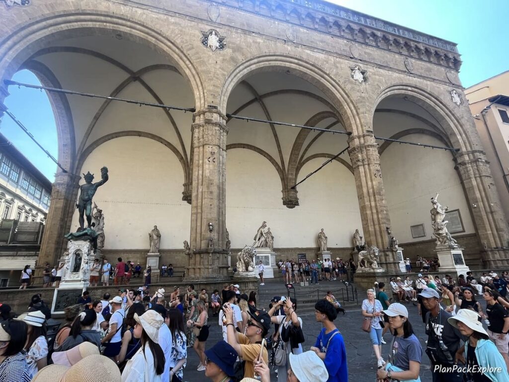 An outdoor area with arches and sculptures inside, called Loggia dei Lanzi in Florence.