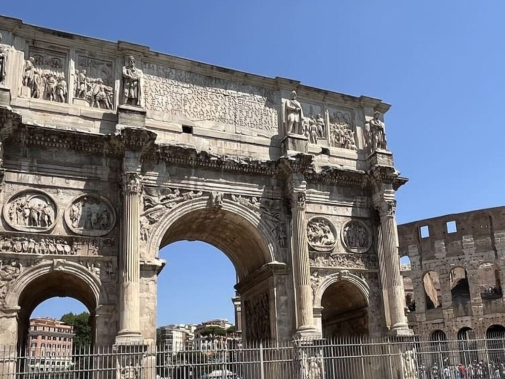 A stone arch with part of the Colosseum visible in Rome Italy.
