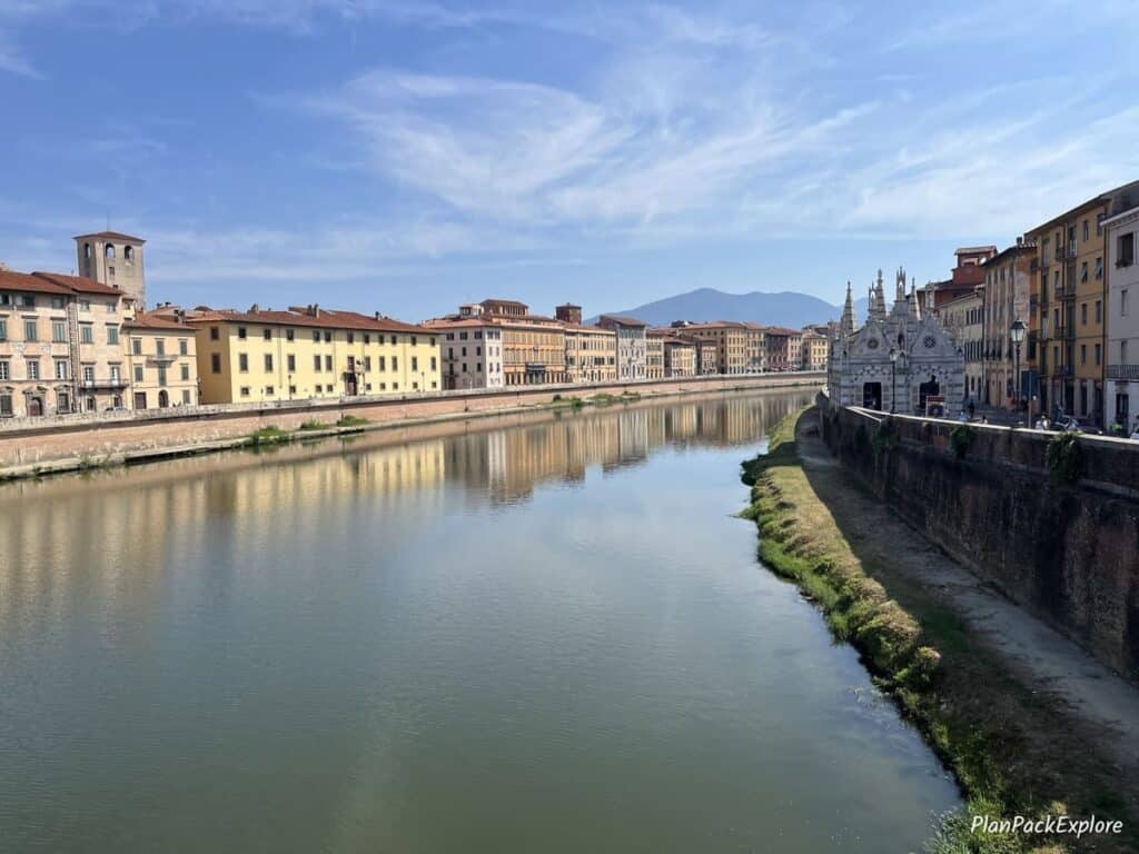 Arno river with historic houses on both banks in Pisa, Italy.