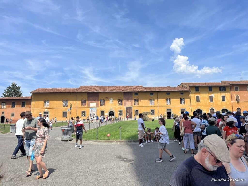 A long rust-colored building in the Square of Miracles in Pisa, housing the Opera del Duomo Museum.