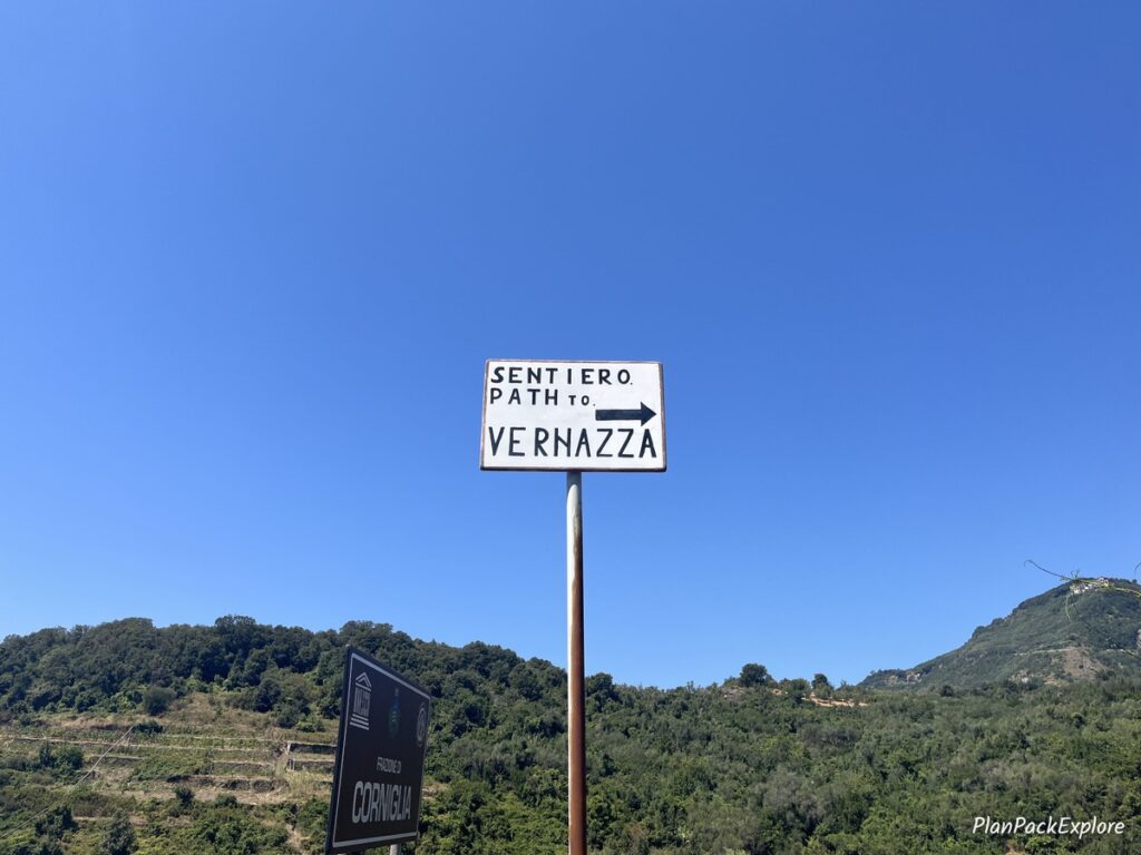 A white sign with black letters for the Sentiero Azzurro Trail in Cinque Terre, Italy.