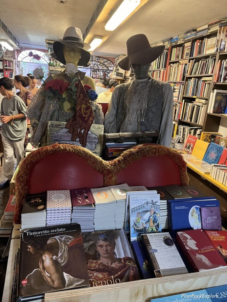 Two puppets pretending to ride the gondola in a bookstore in Venice, Italy.
