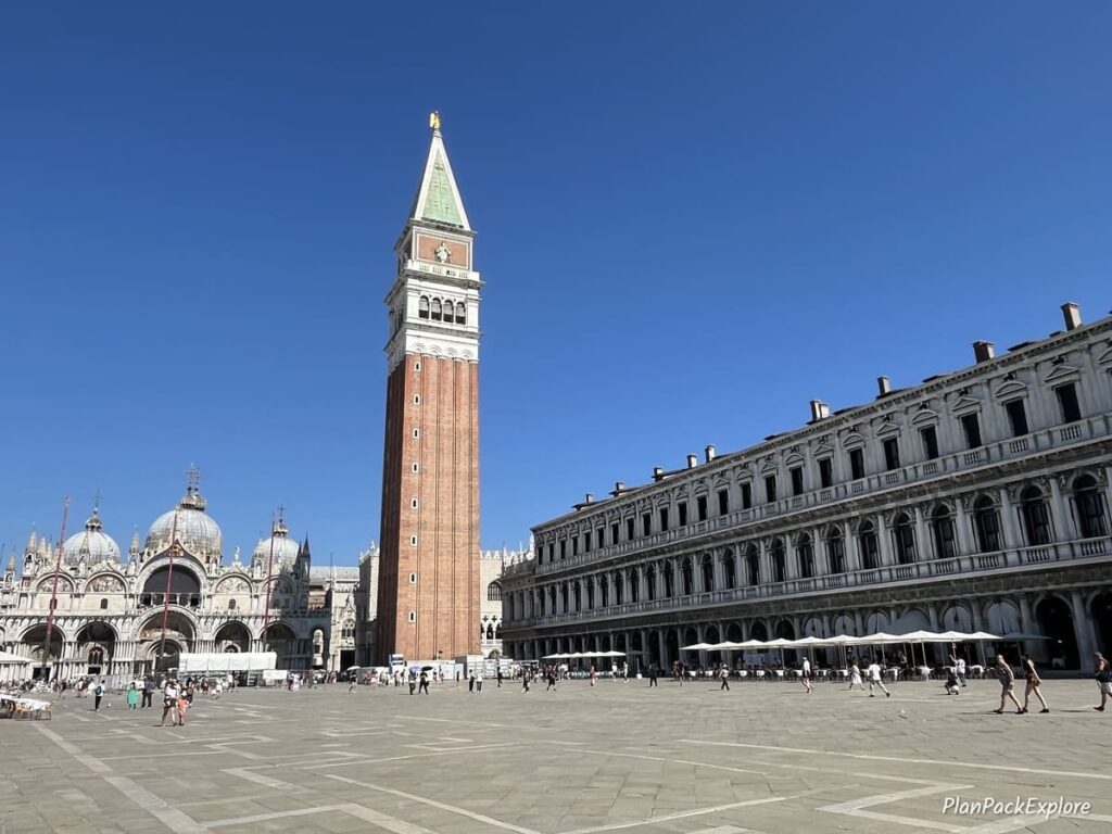 A large plaza with a tall bell tower in the center, called Piazza San Marco in Venice, Italy