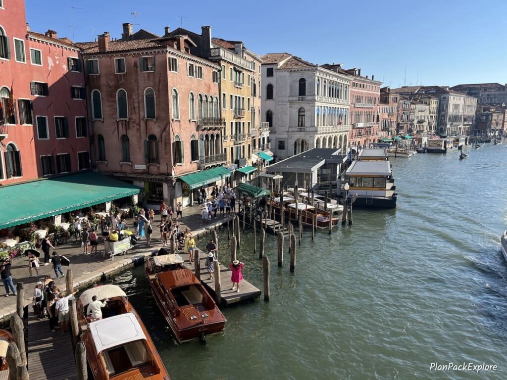 A view of boats and gondolas docked at the Grand Canal from the Rialto Bridge in Venice, Italy.