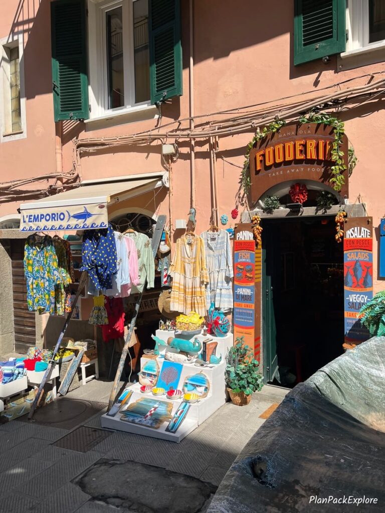 An entry to a souvenir show in Manarola, Cinque Terre, with different items displayed outside.