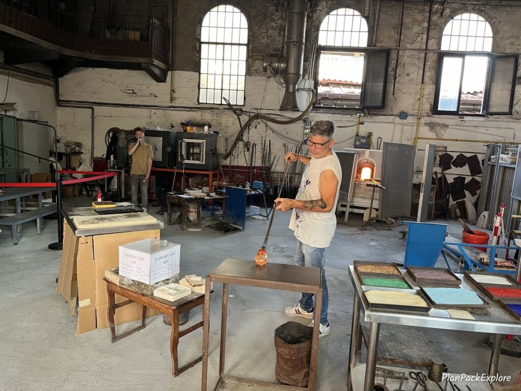 A man working with glass at a glass factory on Murano Island near Venice, Italy.