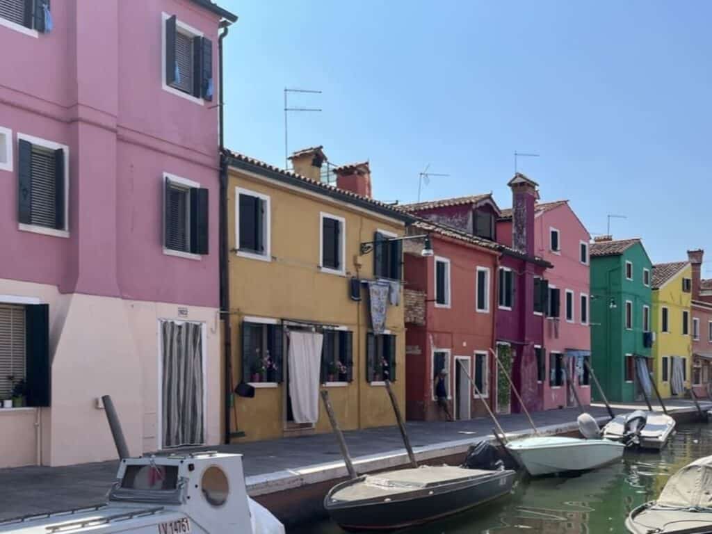A row of colorful houses along the canal on the island of Burano, Italy.