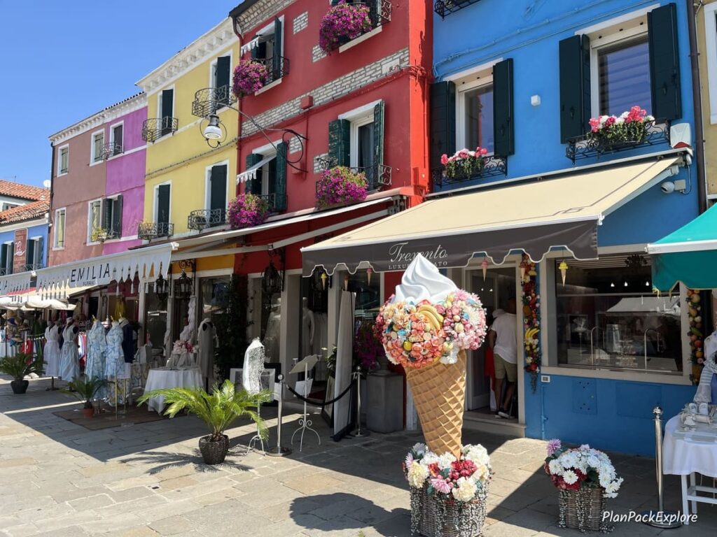 A row of shops and cafes at a main square on Burano Island in Italy.