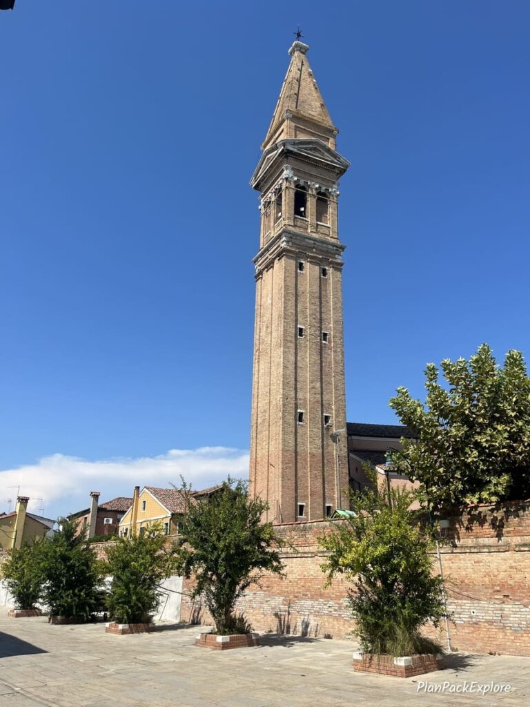 A tall bell tower of a church on Burano Island in Italy.