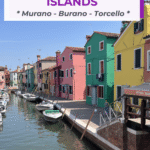 A canal in Burano, one of the Venice lagoon islands, lined with colorful houses and boats along the waterway.