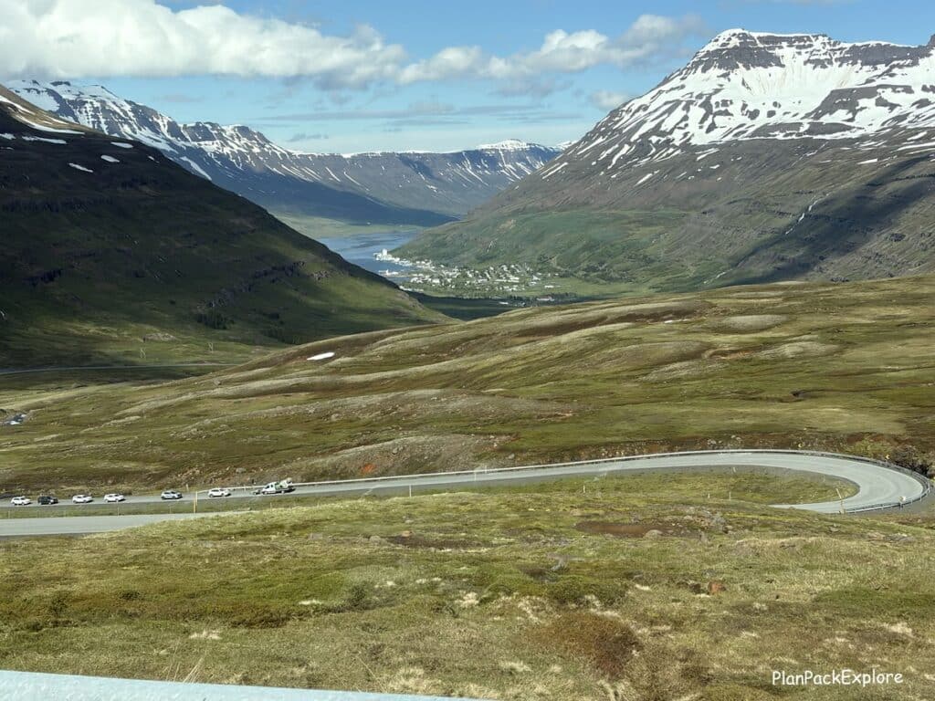 A winding road with snow-capped mountains in Iceland.