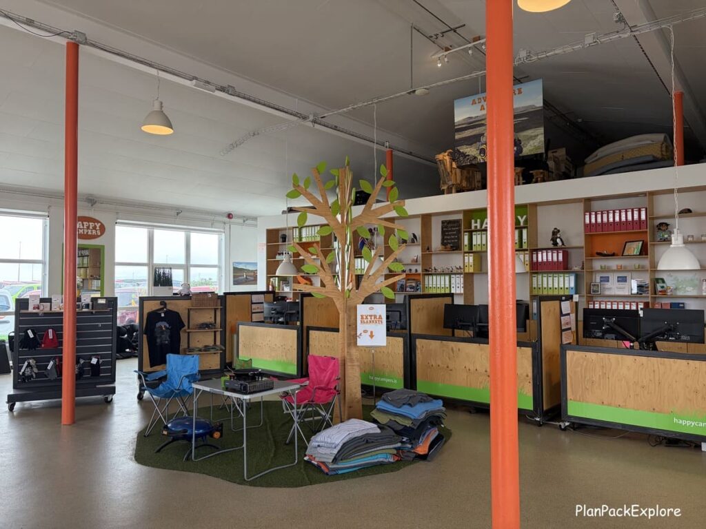 An area inside a campervan rental office in Iceland with spare chairs and blankets displayed.