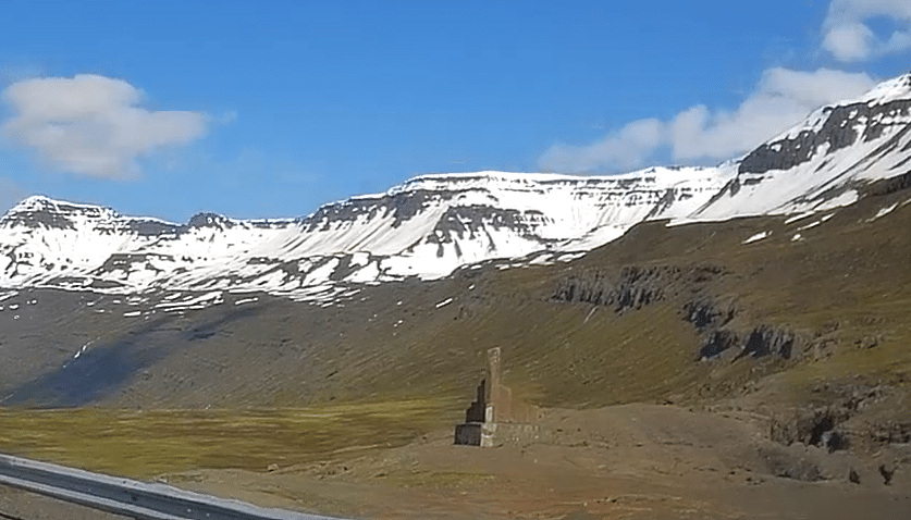 A small basalt column monument on the side of a mountain road leading to Seydisfjordur, Iceland.