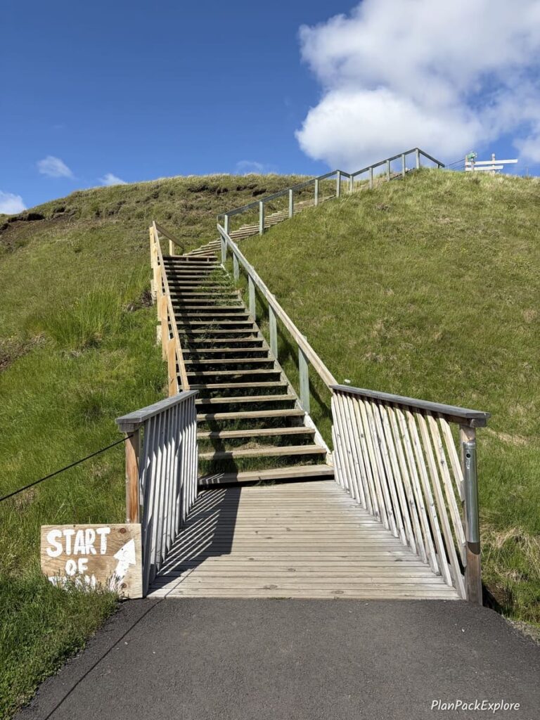 A wooden staircase leading to the start of the hiking trail to Hengifoss Waterfall in Iceland.