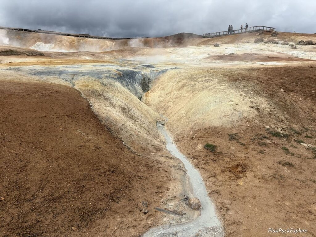 A viewing deck over a colorful area with steam vents at Leirhnjukur Lava Field in Iceland.