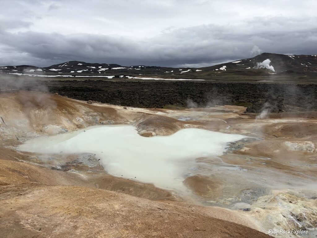 A small pool with milky white water and steam around it at Leirhnjukur Lava Field in Iceland.
