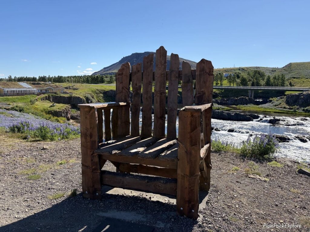 A large wooden chair with a river in the background on the Silver Circle in Iceland.