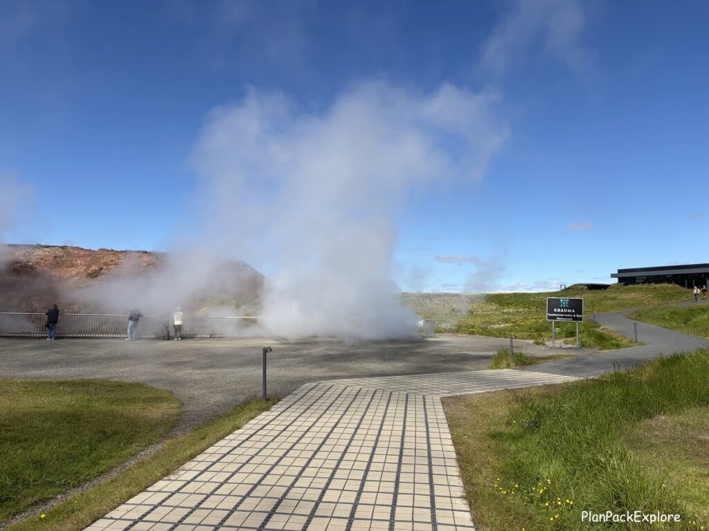 A parking lot with a steaming hot spring called Deildartunguhver on the Silver Circle in Iceland.