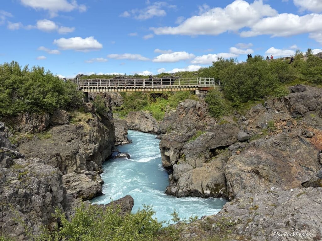 A wooden pedestrian bridge over the river on the Silver Circle in Iceland.
