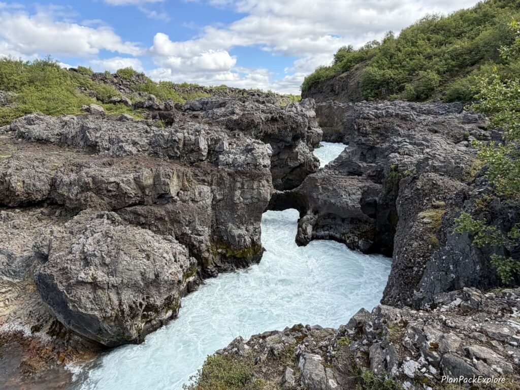 A waterfall surrounded by rocky lava structures, called Barnafoss, on the Silver Circle in Iceland.