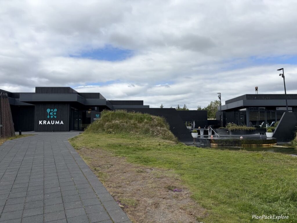 The outside view of black buildings and pools of Krauma Geothermal Baths on the Silver Circle in Iceland.