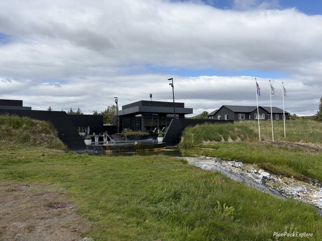 The outside view of black buildings and pools of Krauma Geothermal Baths on the Silver Circle in Iceland.